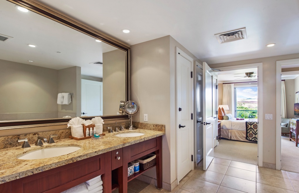 Master bath features a double vanity, a glass walk-in shower, and a separate soaking tub