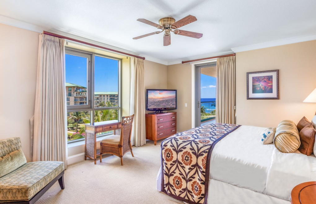 The spacious master bedroom features a king-size bed and balcony access