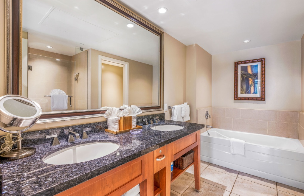 The first bathroom features a double granite vanity