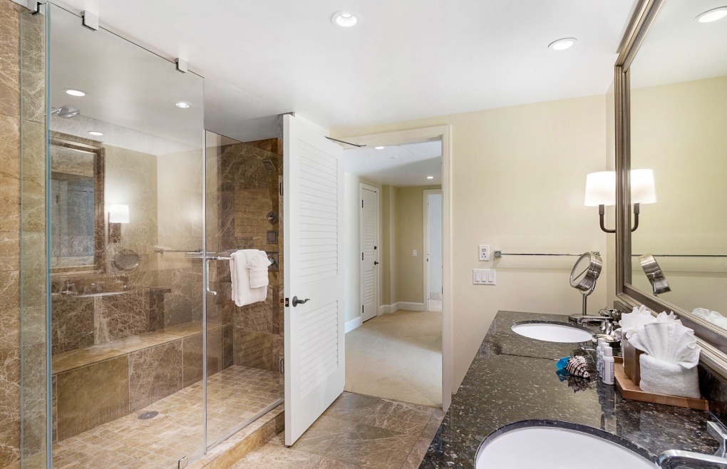 With an elegant freestanding tub and an oversize glass and marble walk-in shower