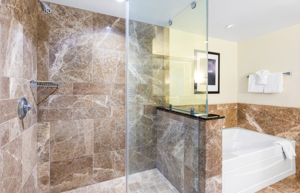 With a glass and marble walk-in shower and a separate soaking tub